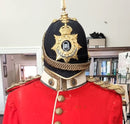 An Edwardian Blue Cloth Helmet, Tunic with waist sash, Trousers, and pattern Wellington boots to an Officer in The Northamptonshire Regiment.