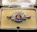 Traditional Rising Sun design marked 9 CT with detailed enamel in its jewellers case.