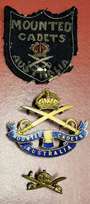 An ultra rare Mounted Cadets set of badges 1900 to 1912 period. Cossum 106. Comprising Bullion patch (showing wear), a near mint enamel Hat badge by Stokes and a single collar.