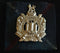 THE KING’S OWN SCOTTISH BORDERER’S CAP BADGE ON TARTAN