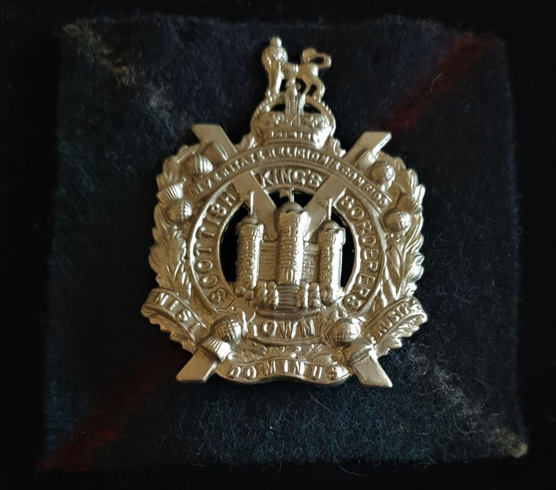 THE KING’S OWN SCOTTISH BORDERER’S CAP BADGE ON TARTAN