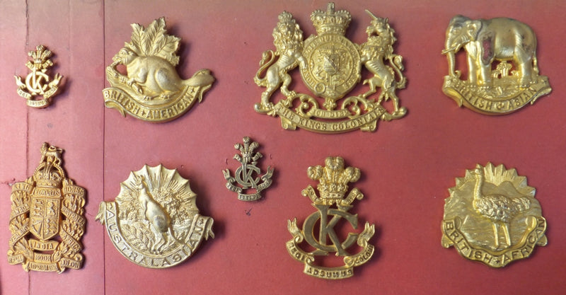 A Selection of 9 KINGS COLONIAL INSIGNIA. A very fine carded display of unissued examples. All with original Gilt. This collection of badges comes from the original J.R. Gaunt and Son Ltd - SOLD